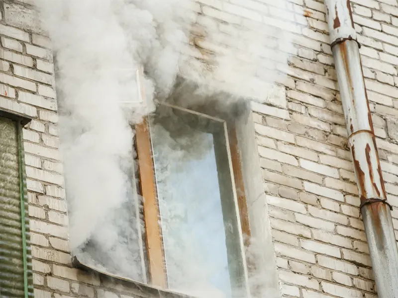 Smoke coming out of a window. Best Cleanup offers smoke cleanup services in Gastonia and beyond.